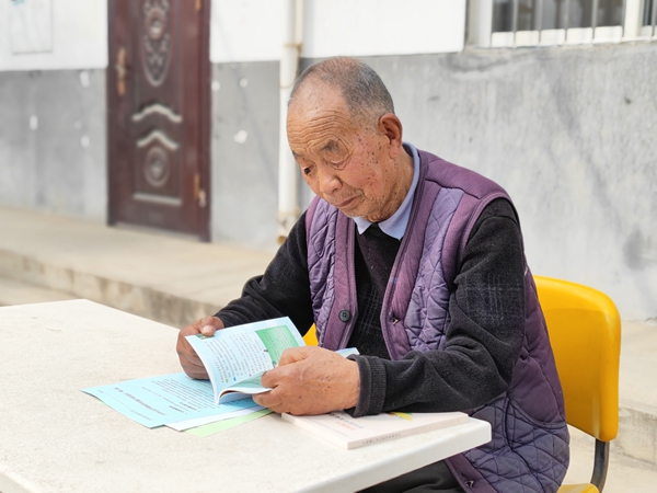 村民大爷刚拿到发下去的科普宣传资料就认真学习起来.jpg